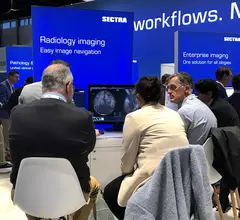 Attendees at RSNA 2022 in the Sectra booth learning about how enterprise imaging can help with workflows and connect numerous departments together for imaging. Photo by Dave Fornell 